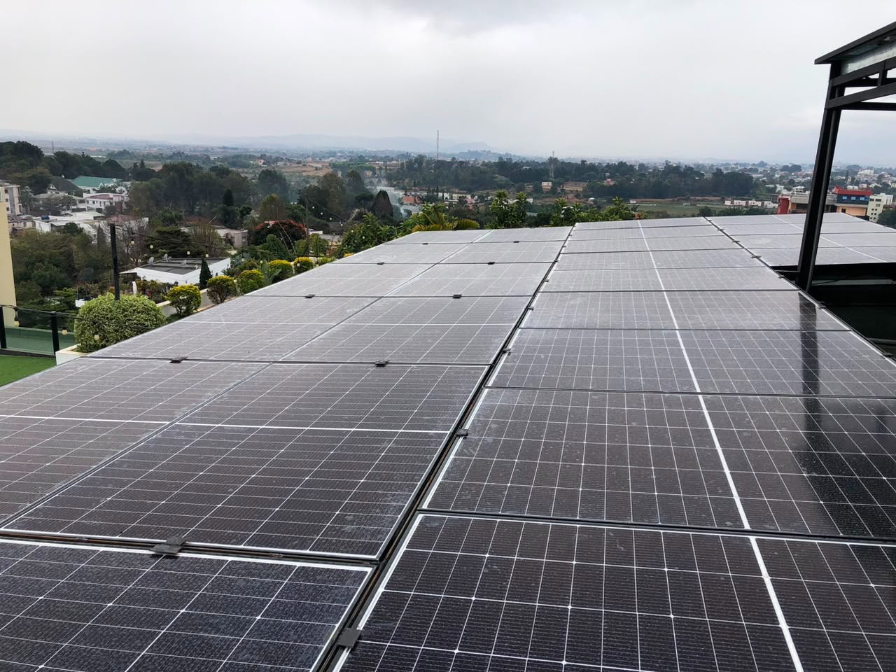 Vue d'ensemble des panneaux solaires en toiture avec vue sur Antananarivo